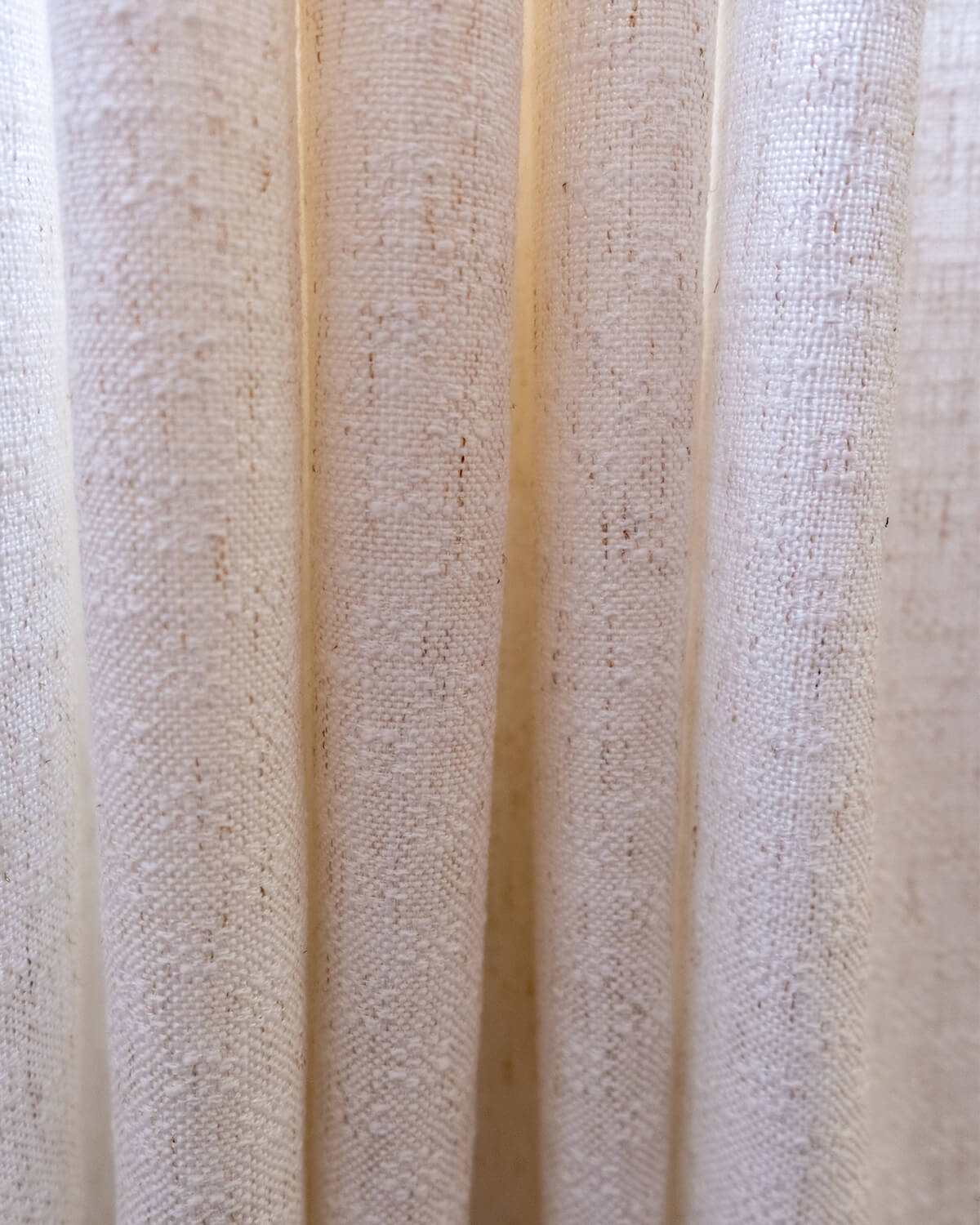 An extreme close-up of the rich, slubby weave of the Alma linen blend fabric.