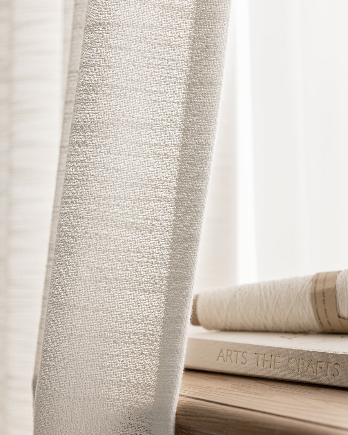 A close-up of the finely textured weave of the off-white Sophie light-filtering curtain.