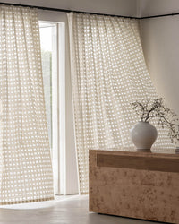 Lightweight Aria sheer check curtains moving gently in the breeze, showcasing their airy quality.