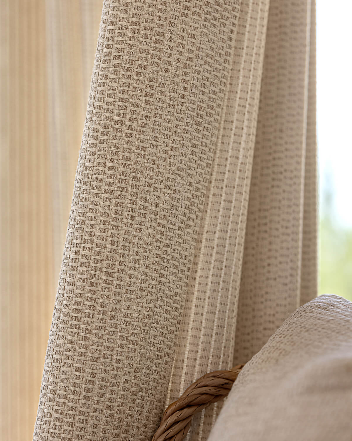 A close-up of the intricate, hand-woven-like basket-weave texture of the beige Margot drape.