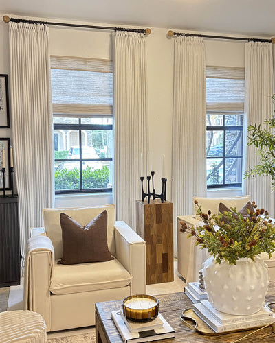 Alma linen texture drapes styled with woven wood shades in a sophisticated living room.