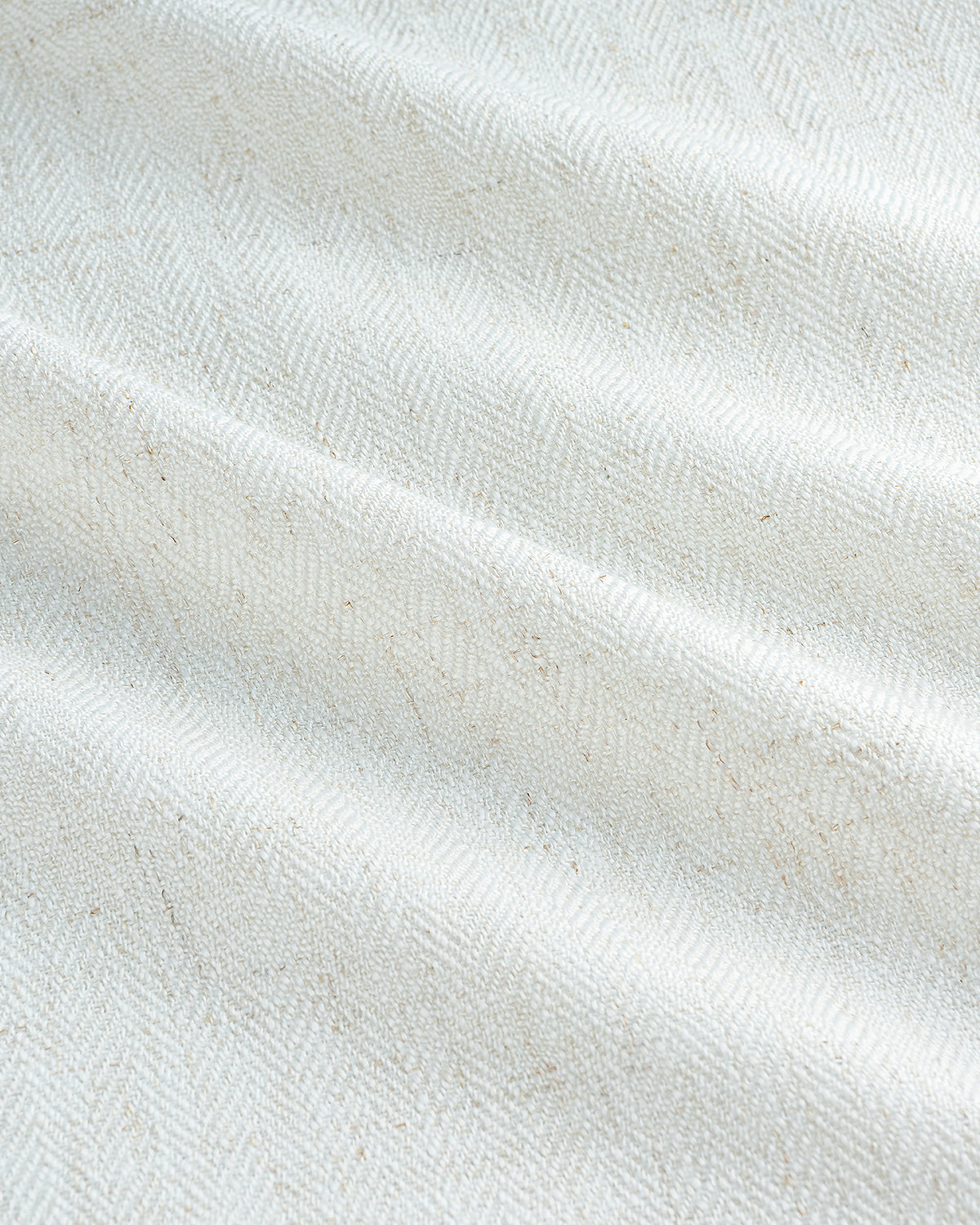 A close-up texture shot of the Luma curtain fabric, revealing the intricate herringbone weave of the linen blend.