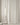A full wall of the Sophie supple curtains in off-white behind a modern floor lamp.
