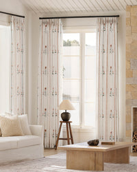 Lily cosmos pinch pleated floral curtains styled in a bright, modern living room