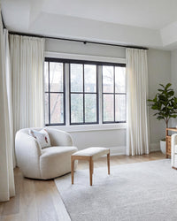 Luma herringbone linen curtains creating a soft, light-filtering backdrop in a neutral-toned living room.