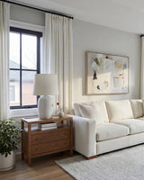 White Luma herringbone curtains framing a window behind a cream sofa and abstract wall art.