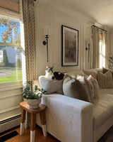 Aurelia ditsy floral pinch pleated floral curtains installed in a cozy living room with a cat on the sofa