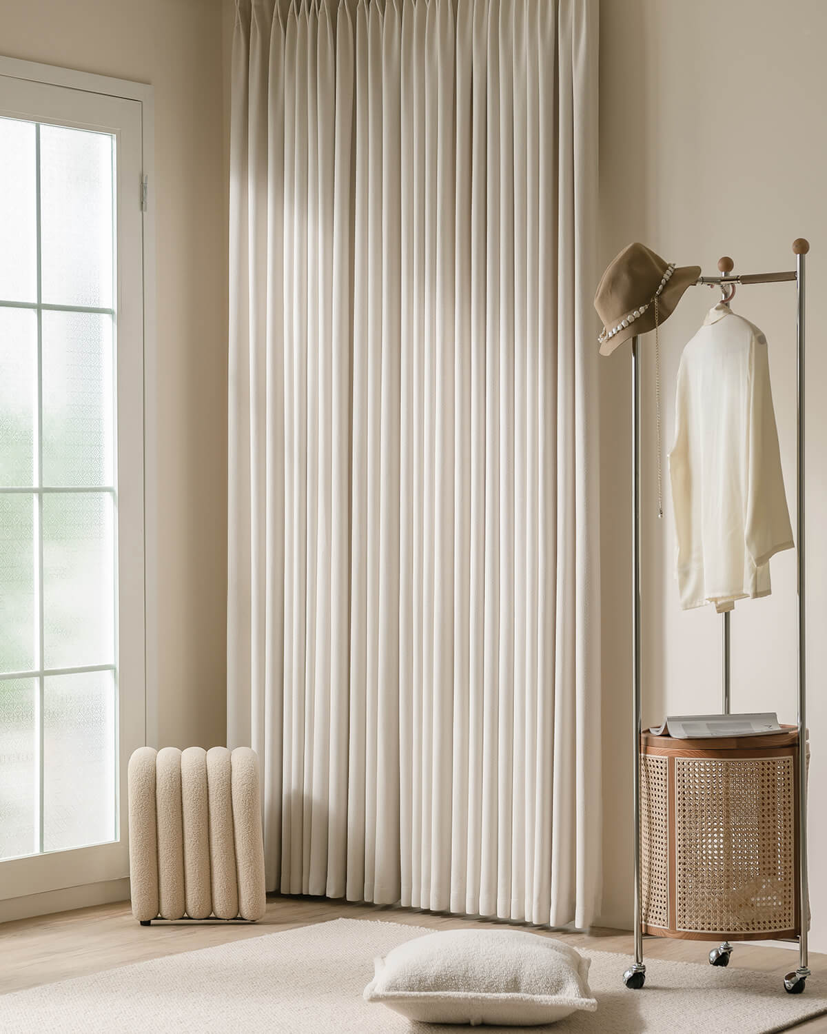 A full view of the heavy Kely Chenille pinch pleated curtains in a modern, minimalist bedroom setting.