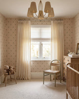 Lightweight pinstripe beige curtains for bedroom styled over a white Roman shade next to a modern wooden chair.