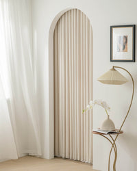 Kely Chenille pinch pleat curtains used to frame an arched doorway in a minimalist interior.