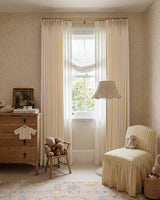 Darcy beige cotton blend curtains with pinstripe pattern in a cozy room featuring a yellow striped armchair.