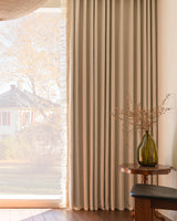Side view of waffle textured drapes with ruffle edge filtering natural light, creating a warm atmosphere in the living room.