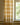 A pair of Ivy woven striped curtains filtering light while framing a tall window.