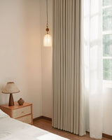 Vivi Chenille 99% blackout curtains in a soft beige, styled in a cozy bedroom with a modern nightstand.