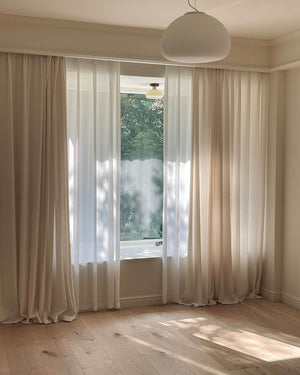 The June sheer curtains softly diffusing sunlight across a warm, modern living space.