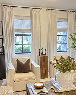 Alma linen texture drapes styled with woven wood shades in a sophisticated living room.